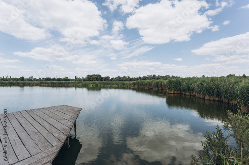 summer lake with a wooden bridge displaying the sky
