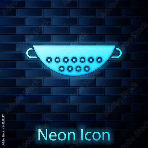 Glowing neon Kitchen colander icon isolated on brick wall background. Cooking utensil. Cutlery sign.  Vector Illustration