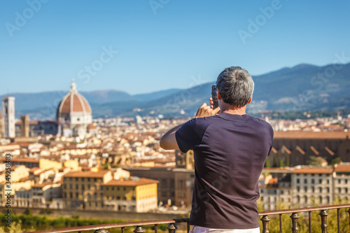 caucasian mature man taking a shot of Florence on his cell phone