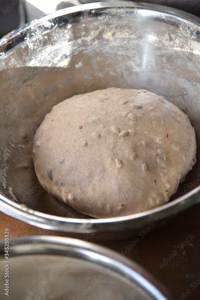 Handmade bread dough rising in a stainless steel bowl Handmade bread dough rising in a stainless steel bowl