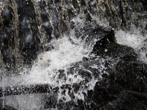 water splash on black stone rock © Miljan Andjelkovic