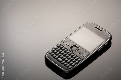An outdated mobile phone with a screen for copying space on a gray gradient background. The minimalist trend. smartphone. with copy space for text.
