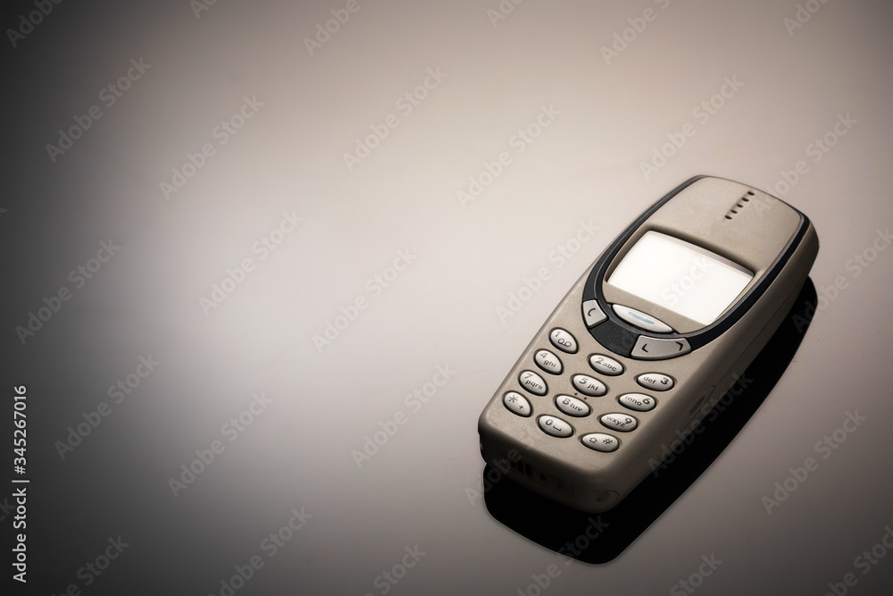 An outdated mobile phone with a screen for copying space on a gray gradient background. The minimalist trend. smartphone. with copy space for text. An outdated mobile phone with a screen for copying space on a gray gradient background. The minimalist trend. smartphone. with copy space for text.