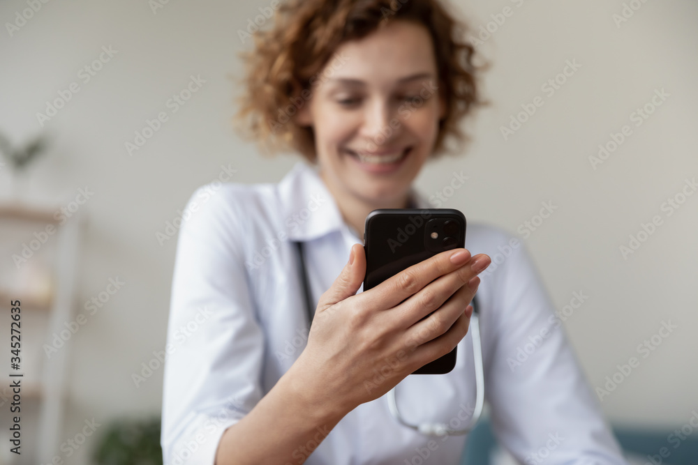 Female doctor holding smartphone in hands using mobile apps consulting patient online. Practice of medicine and public health care supported by mobile devices concept. Close up view, focus on phone Female doctor holding smartphone in hands using mobile apps consulting patient online. Practice of medicine and public health care supported by mobile devices concept. Close up view, focus on phone