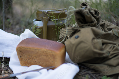 military backpack, bread and military flask lie on a white towel