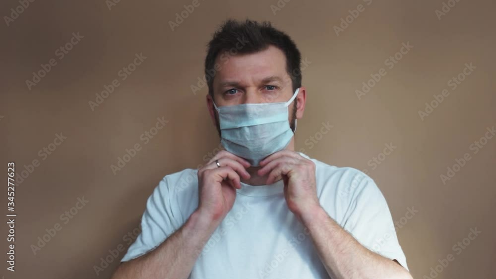 young man putting on surgical mask for corona virus prevention young man putting on surgical mask for corona virus prevention