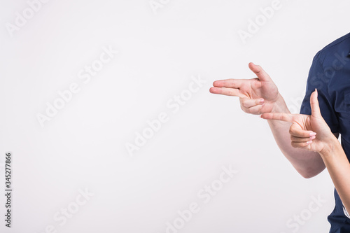 Couple pointing at the left corner with fingers standing isolated over white background. Copy space for product advertisement.