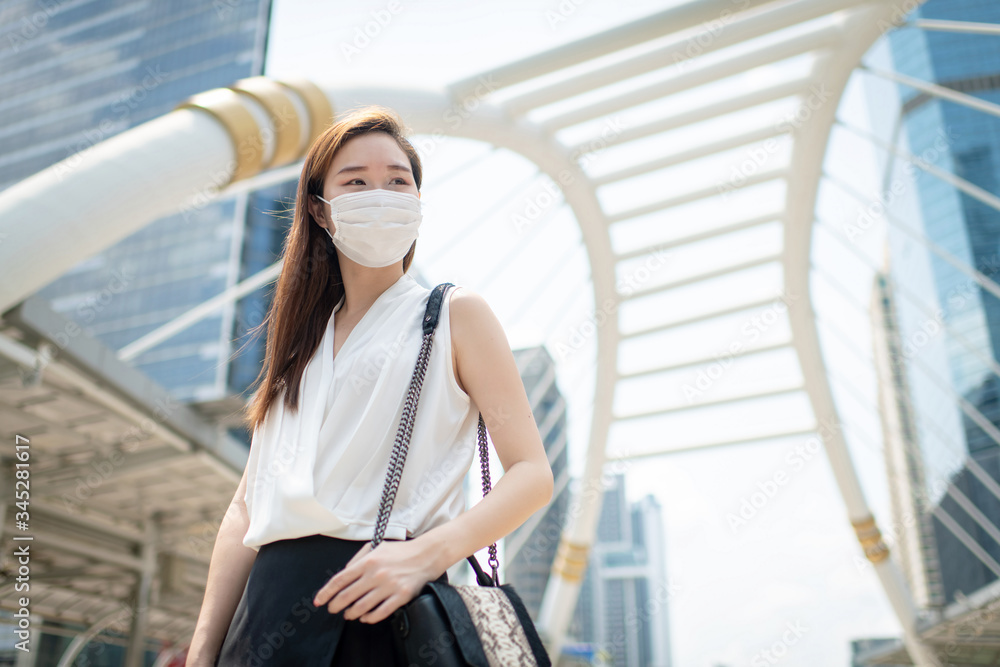 COVID-19 Pandemic Coronavirus Asian Woman in city street going to work. She wearing face mask protective for spreading of disease virus. COVID-19 Pandemic Coronavirus Asian Woman in city street going to work. She wearing face mask protective for spreading of disease virus.