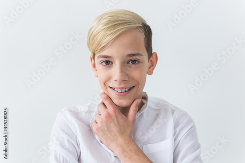 Close-up of teen boy with braces on teeth smiling on white background. Dentistry and teenager concept.