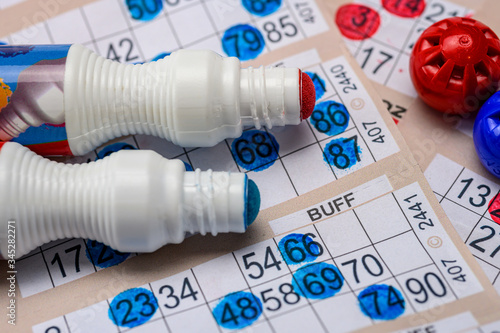 Bingo cards with red and blue markers close up
