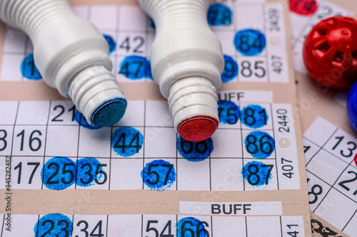 Bingo cards with red and blue markers close up