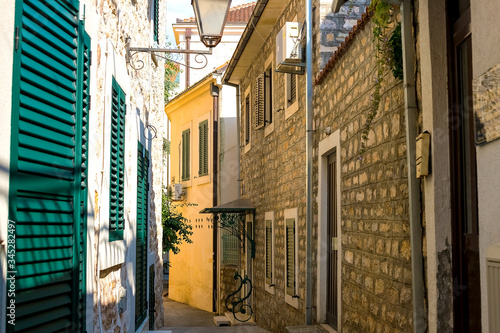 Winding street of the authentic, old town of Herceg Novi, Montenegro. We see old houses and very narrow