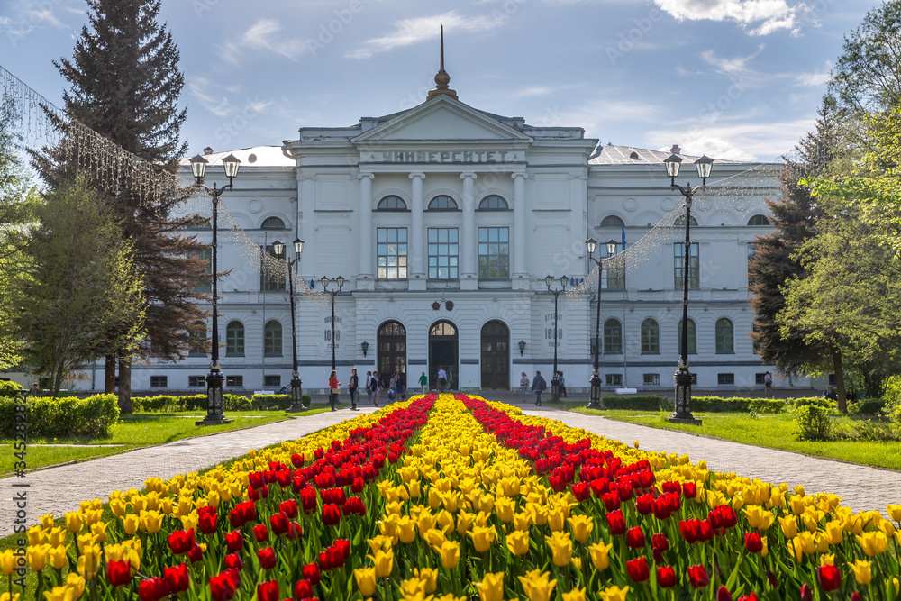 Ταπετσαρία White building of Tomsk State University with tulip flowers in backlight and sun
