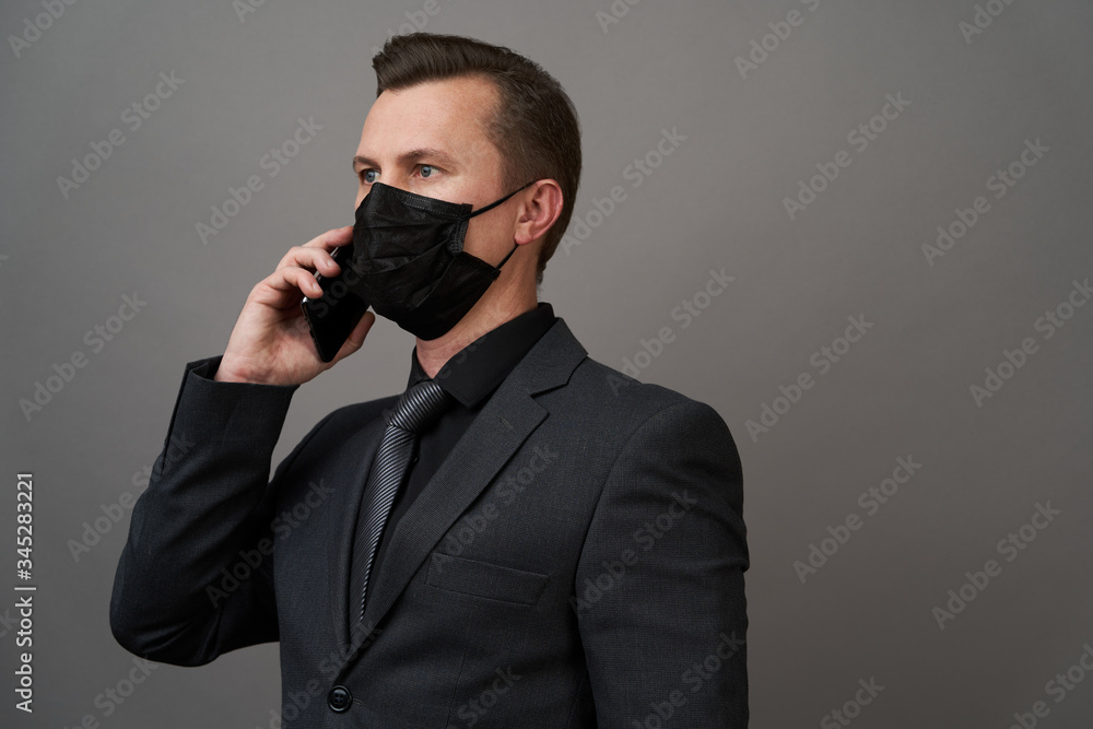 Businessman with surgical medical mask using mobile phone Businessman with surgical medical mask using mobile phone