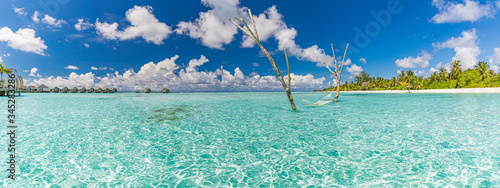 Luxury water hammock in paradise island sea lagoon. Summer beach travel and exotic vacation destination. Blue turquoise water with relaxing and calming inspirational tropical beach landscape 