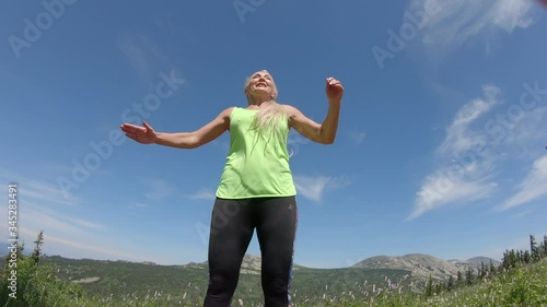 a happy young woman in leggings and a bright green t shirt jumps beautifully in the air against the background of a mountain valley. outdoor fitness, Sports and healthy lifestyle. Pretty fit girl photo