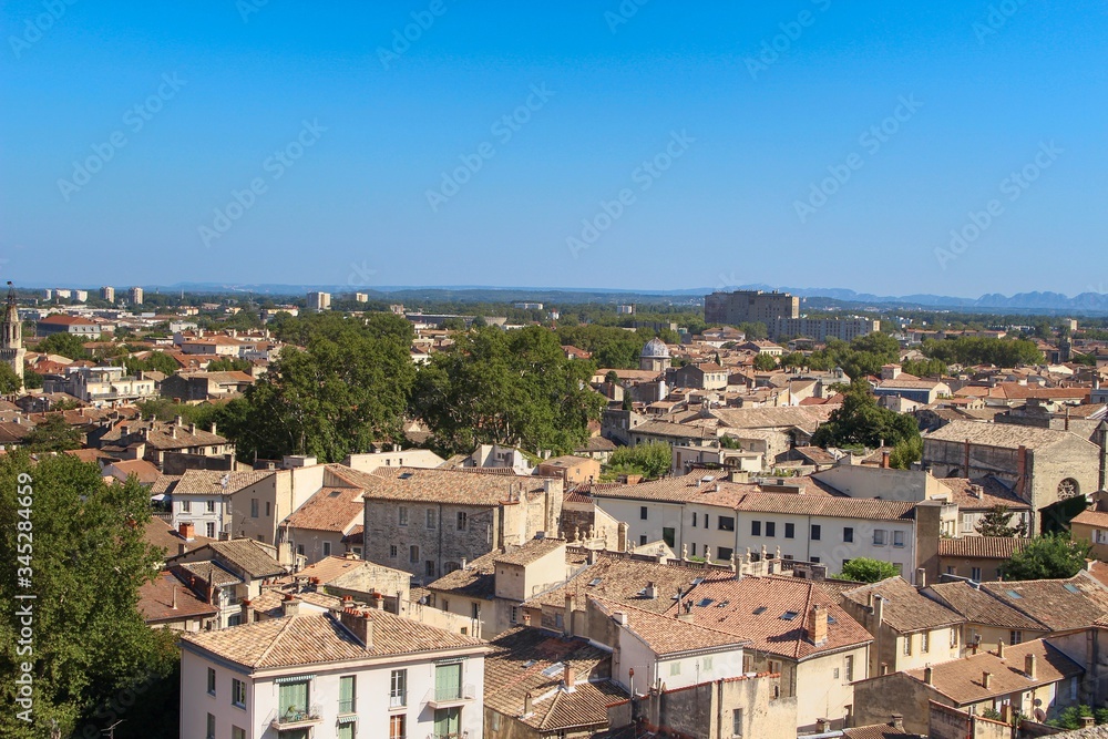 Beautiful summer photo of the roofs of houses taken from a city park in Avignon, France (commune in South-Eastern France in the department of Vaucluse on the left bank of the Rhône river)