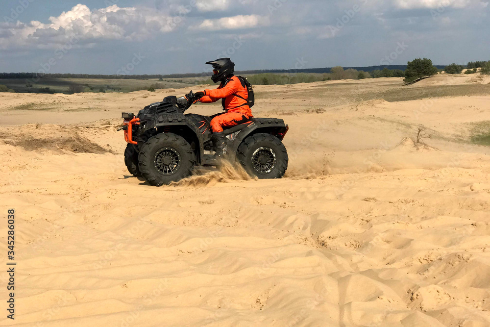 Obraz premium A man riding a quad bike in the desert