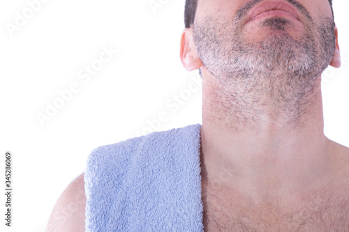 male face and neck with bristles and a towel on his shoulders