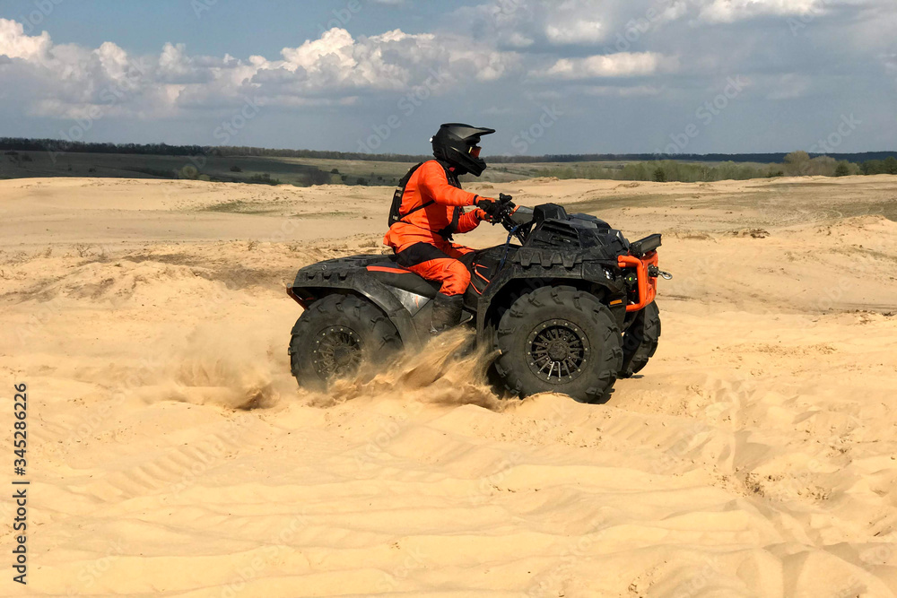 A man riding a quad bike in the desert A man riding a quad bike in the desert