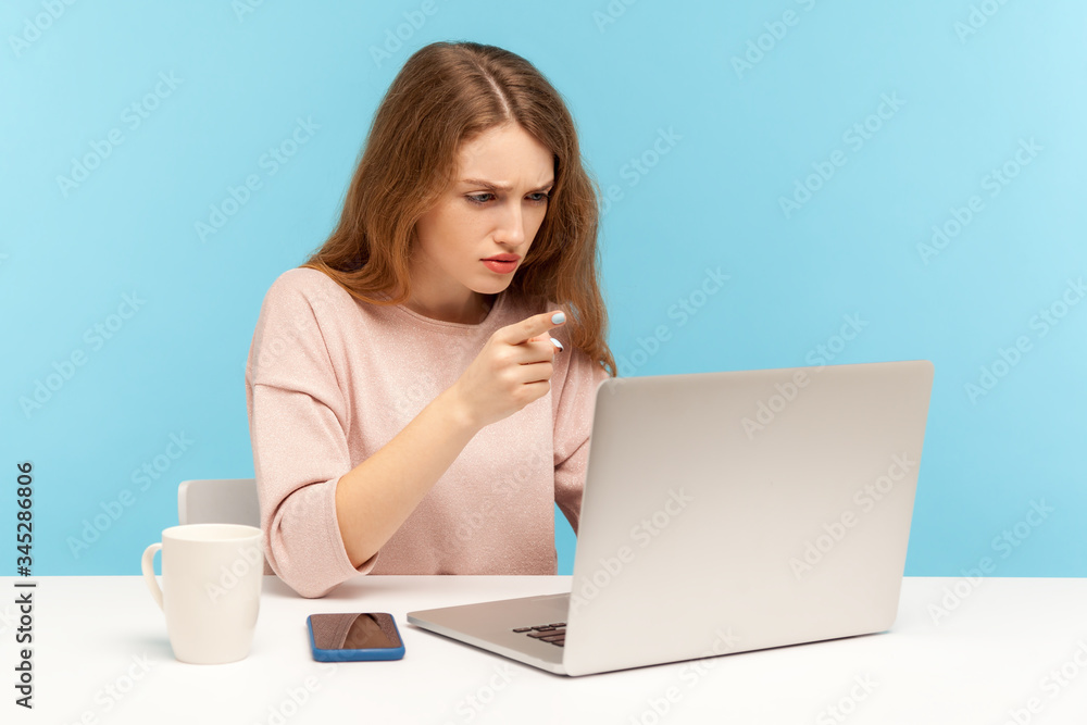 Be careful! Bossy woman looking at laptop screen and warning with admonishing finger gesture, giving advice on video call, online conference at home office. indoor studio shot, blue background Be careful! Bossy woman looking at laptop screen and warning with admonishing finger gesture, giving advice on video call, online conference at home office. indoor studio shot, blue background