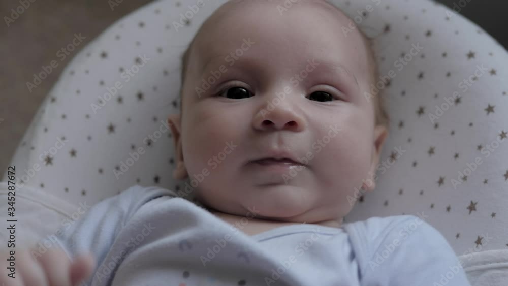 Different Facial Expressions Of Newborn Child Looks At Camera And Pulls Handles Different Facial Expressions Of Newborn Child Looks At Camera And Pulls Handles