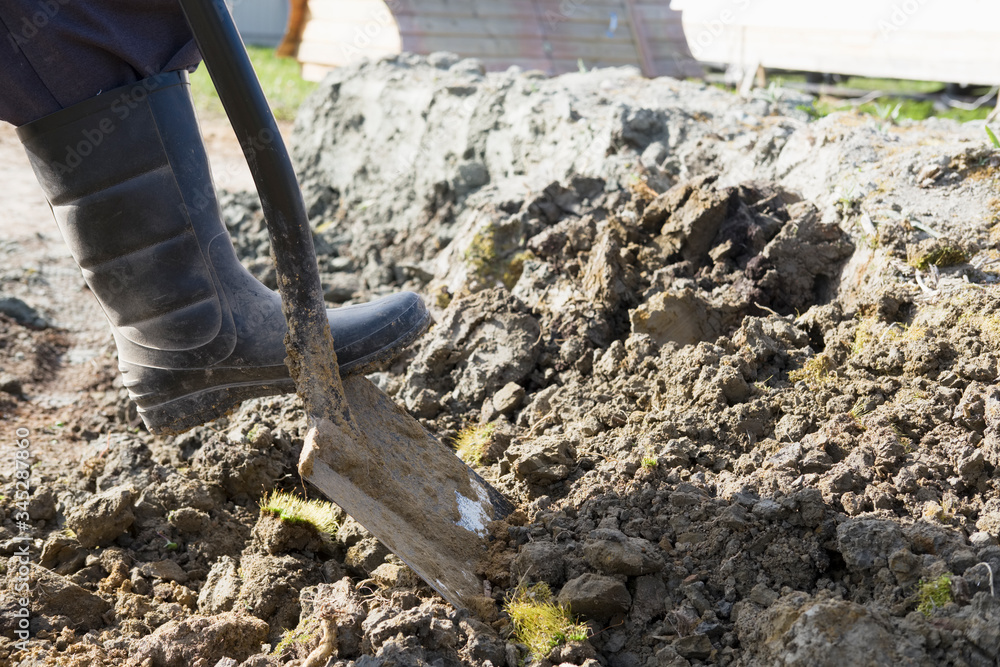 Digging the earth with a shovel in boots Digging the earth with a shovel in boots