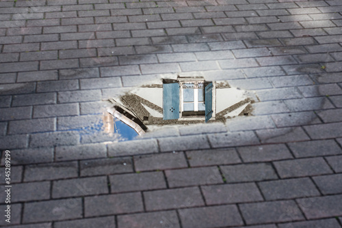 View of traditiobal architecture in the reflect of the puddle of water in Mulhouse - France photo