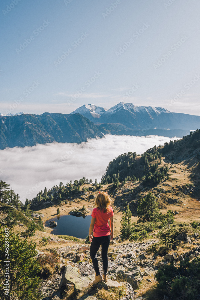 Femme regarde le paysage de montagne avec des nuages