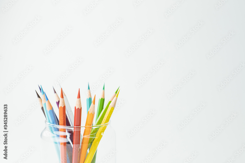 Bright pencils in a glass isolated on white background.as banner concept of work from home WFH with copy space for runaround or wraparound text. Bright pencils in a glass isolated on white background.as banner concept of work from home WFH with copy space for runaround or wraparound text.