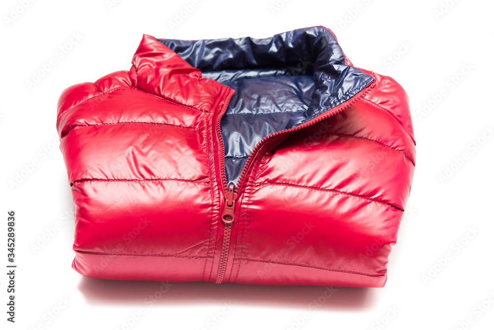 Folded blue and red full zipper windbreaker down jacket, rain proof down jacket. Down jacket sport shiny nylon full zip isolated on white. Folded clothes. Folded blue and red full zipper windbreaker down jacket, rain proof down jacket. Down jacket sport shiny nylon full zip isolated on white. Folded clothes.