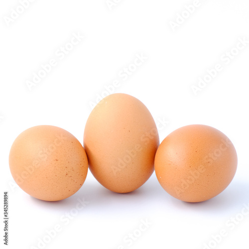 Close-up top view of organic raw eggs on white background with copy space for your text, healthy eating concept.