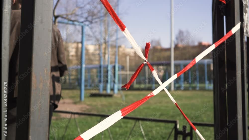 Young man in leather jacket was stopped by the red tape. Stadiums and playgrounds are closed due to COVID-19 coronavirus pandemic quarantine in Russia.