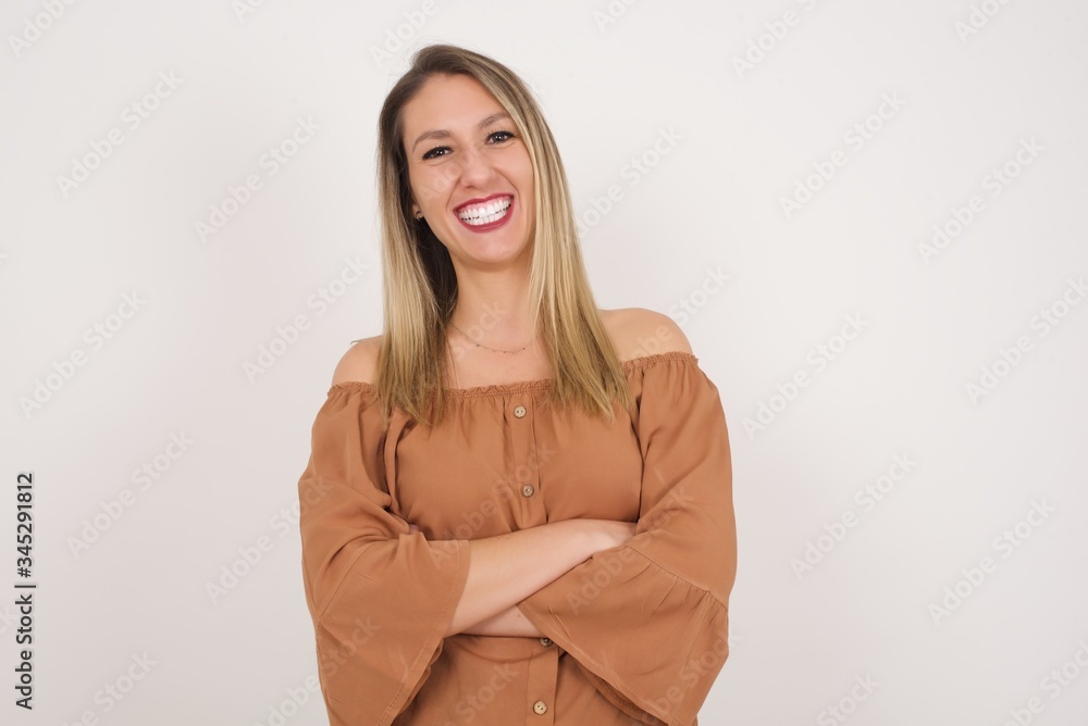Brunette girl happy face smiling with crossed arms looking confident at the camera standing against gray wall. Positive person. Brunette girl happy face smiling with crossed arms looking confident at the camera standing against gray wall. Positive person.