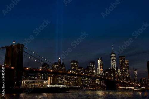 Brooklyn Bridge in the night with Manhattan and the Twin Towers Tribute Lights at the background in 11S memorial day