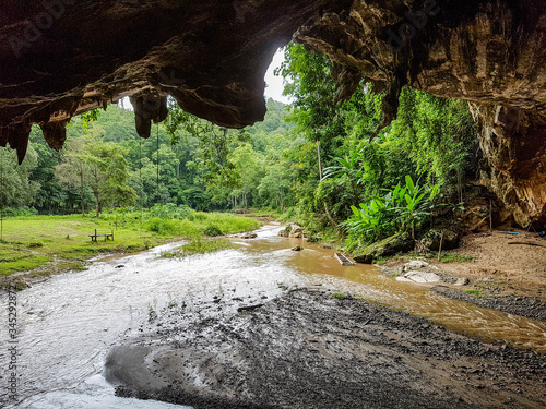 Entry exit stalatite cave river water flowing trees green forest chalk stone limestone pai tour mudder light chiang mai