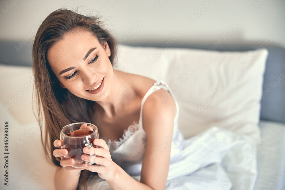 Caucasian happy woman having rest and holding cup in arms Caucasian happy woman having rest and holding cup in arms