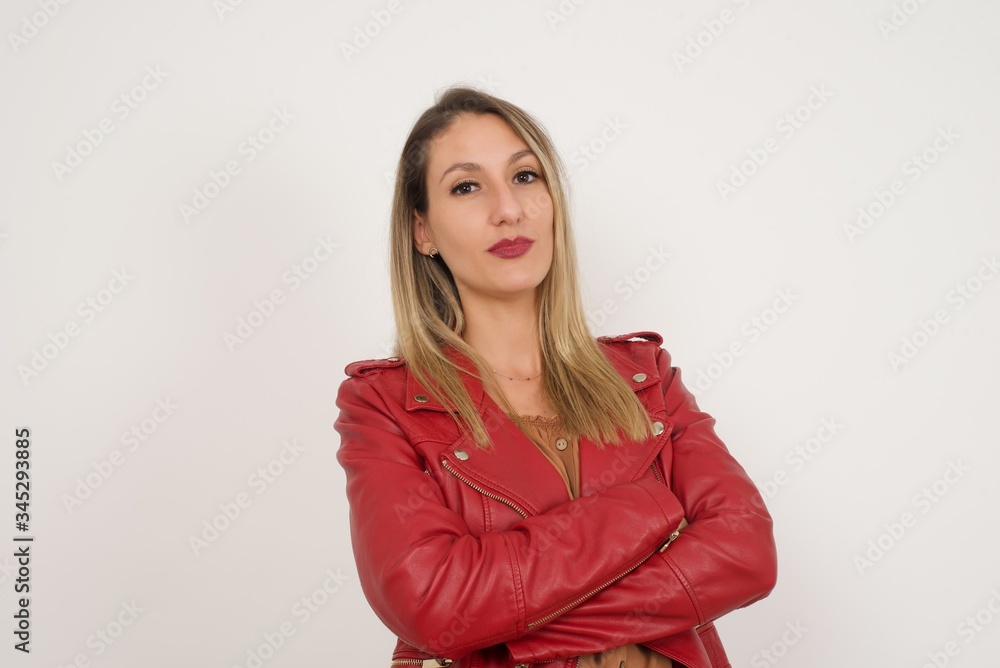 Waist up portrait of beautiful young female with positive expression, has crossed arms, feels happy and confident, wears casual clothes, isolated over gray background Waist up portrait of beautiful young female with positive expression, has crossed arms, feels happy and confident, wears casual clothes, isolated over gray background