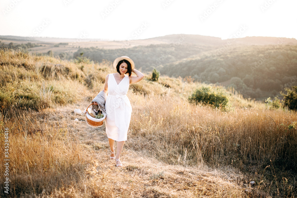 Beautiful girl with hat walks in the mountains and enjoys the sunset. Traveling in evening mountains. Space for text Beautiful girl with hat walks in the mountains and enjoys the sunset. Traveling in evening mountains. Space for text