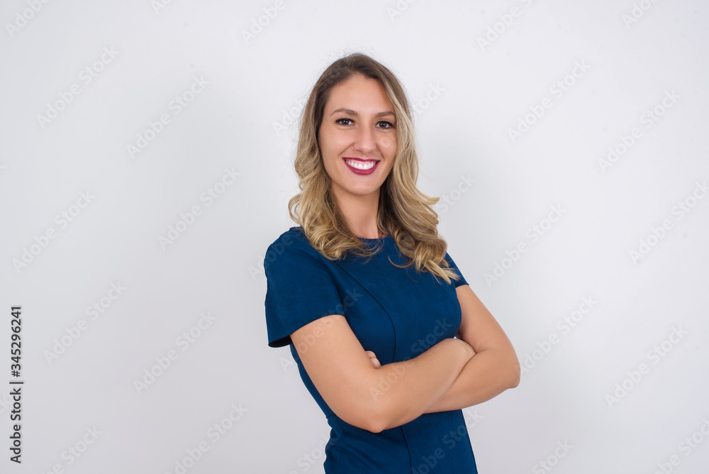 Pretty caucasian lady standing against gray wall with arms crossed wearing casual clothes. Looking and smiling at the camera. Confident successful woman. Pretty caucasian lady standing against gray wall with arms crossed wearing casual clothes. Looking and smiling at the camera. Confident successful woman.