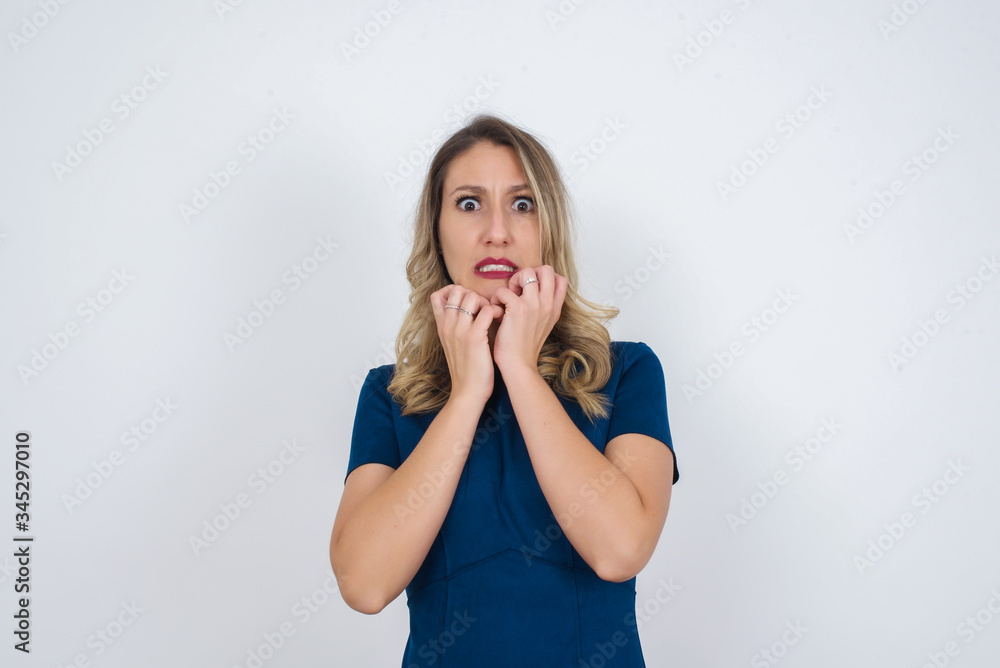 Anxiety - a conceptual image of a beautiful young caucasian woman covering her mouth with her hands and standing outdoors. Scared from something or someone bitting nails. Anxiety - a conceptual image of a beautiful young caucasian woman covering her mouth with her hands and standing outdoors. Scared from something or someone bitting nails.