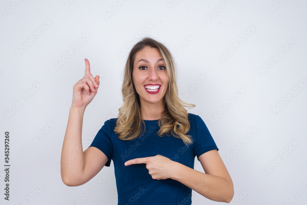 Positive glad female says: wow how exciting it is, has amazed expression, indicates something. Joyful pretty young woman demonstrates something. One hand on her chest and pointing with other hand. Positive glad female says: wow how exciting it is, has amazed expression, indicates something. Joyful pretty young woman demonstrates something. One hand on her chest and pointing with other hand.