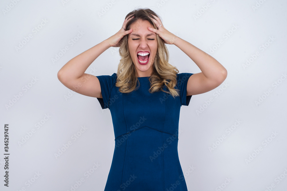 Shocked panic Caucasian girl dressed in stylish clothing holding hands on head and screaming in despair and frustration while being late for plane, her eyes full of terror, mouth dropped open Shocked panic Caucasian girl dressed in stylish clothing holding hands on head and screaming in despair and frustration while being late for plane, her eyes full of terror, mouth dropped open