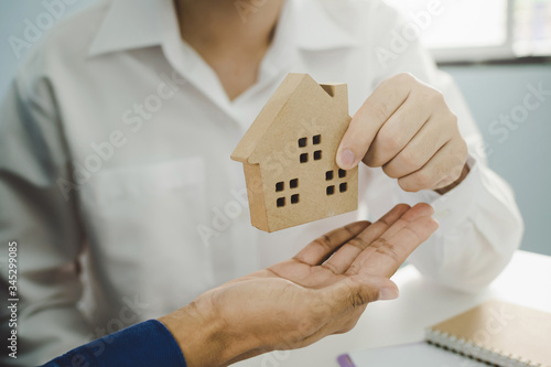 real estate broker manager giving house model to customer after signing contract for buying house in estate agent office, digital marketing, finance, home loan contract, buy and sell house concept