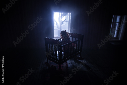 Obraz na plátne Old creepy eerie baby crib near window in dark room