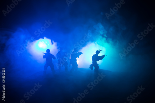 War Concept. Military silhouettes fighting scene on war fog sky background, World War Soldiers Silhouette Below Cloudy Skyline At night.