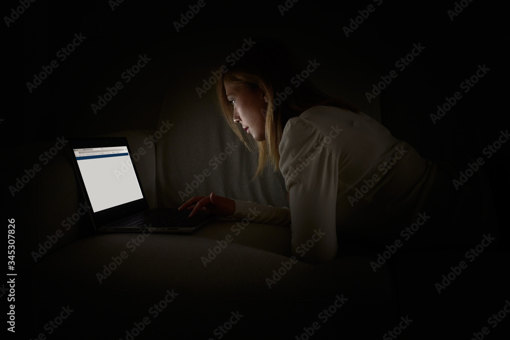 woman with laptop in the dark room woman with laptop in the dark room
