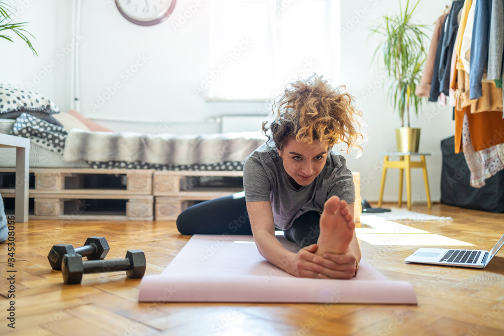 Young woman doing fitness exercise at home
