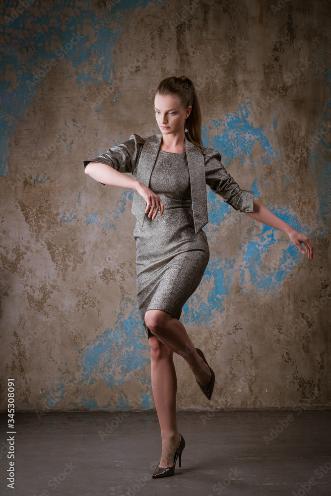 Cute woman posing in a dress on a grunge background