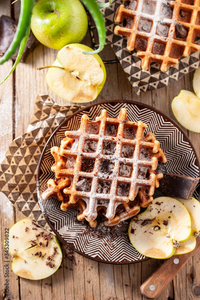 Belgian, french waffles for breakfast. Serving a dessert with chocolate, icing sugar and apples. Belgian, french waffles for breakfast. Serving a dessert with chocolate, icing sugar and apples.